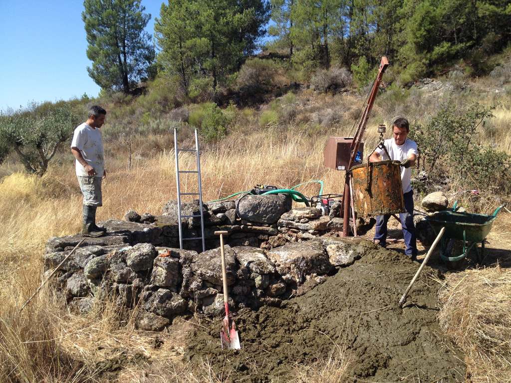 Cleaning an agricultural well in central Portugal, using a small crane to lift muddy sediments to the surface.